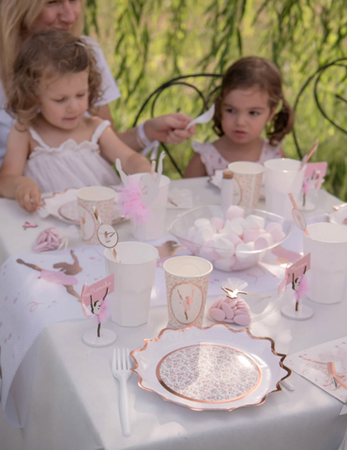Mise en situation sur une table des assiettes en carton floral rose gold chic et romantique