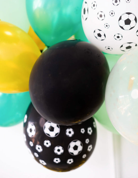 Gros plan sur les motifs ballons de foot des ballons noirs pour fête