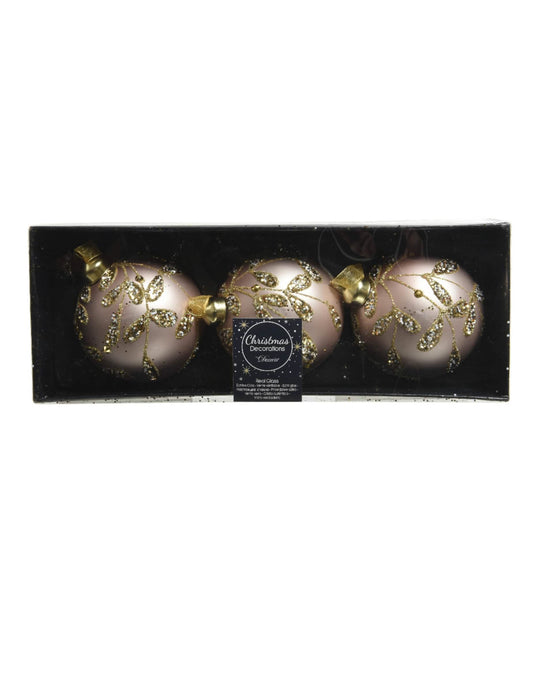 Vue dans leur coffret des boules de noël en verre rose poudré avec feuilles dorées à paillettes