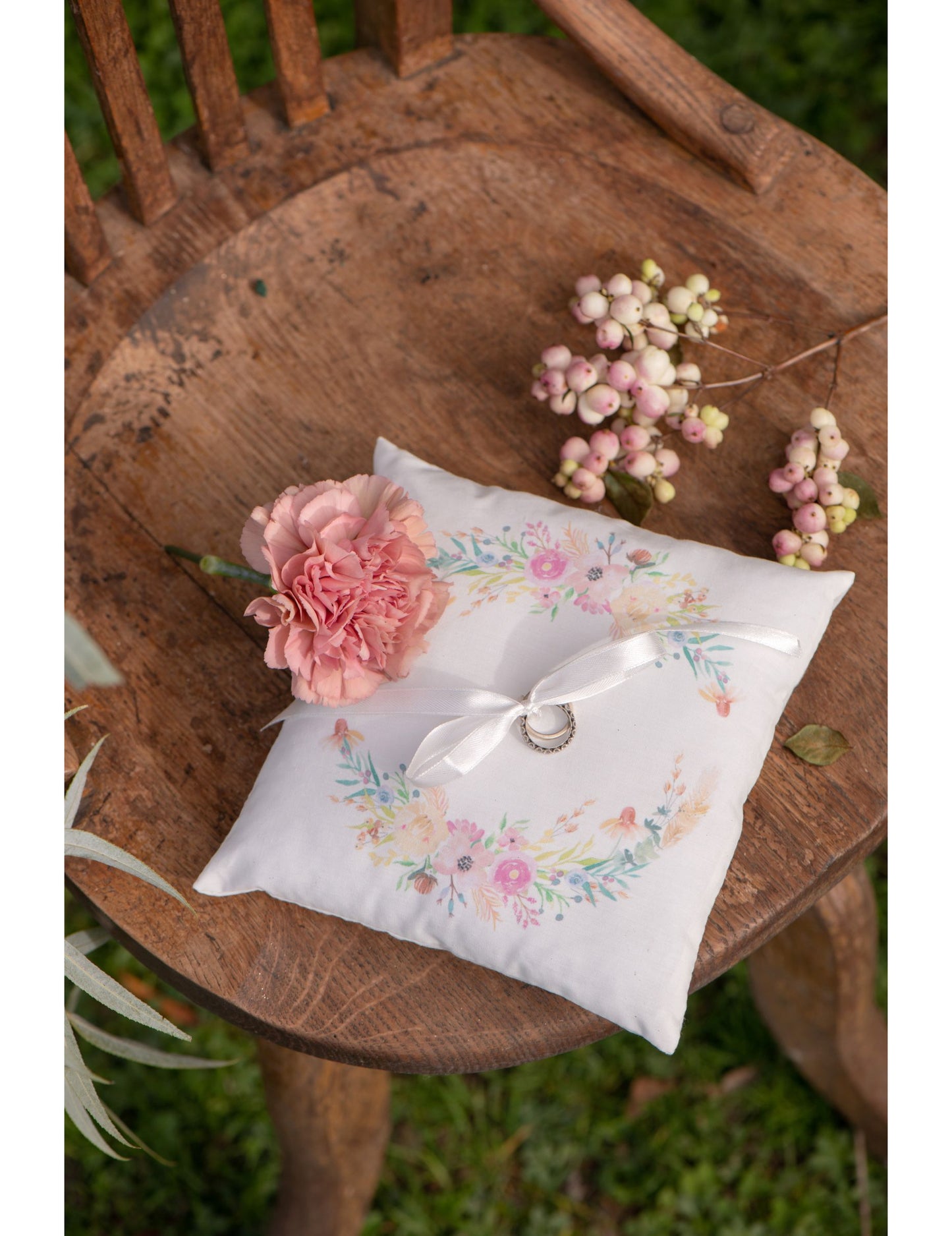 Mise en situation champêtre sur chaise en bois du coussin d'alliances mariage fleuri