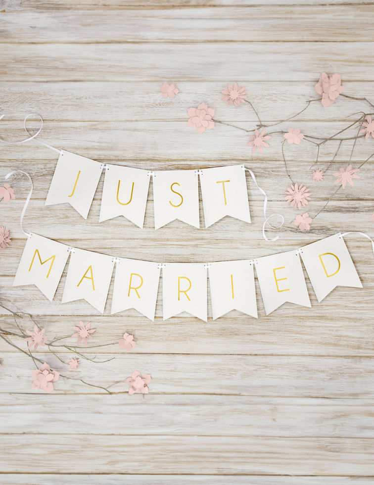 Mise en scène sur fond bois de la guirlande en carton Just Married pour mariage