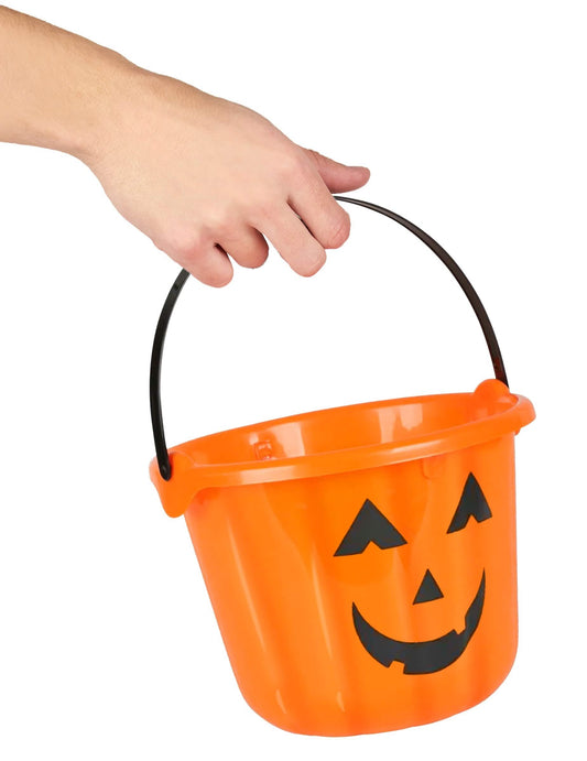 Детайл на дръжката, държана от ръка на тиквена кофа за halloween