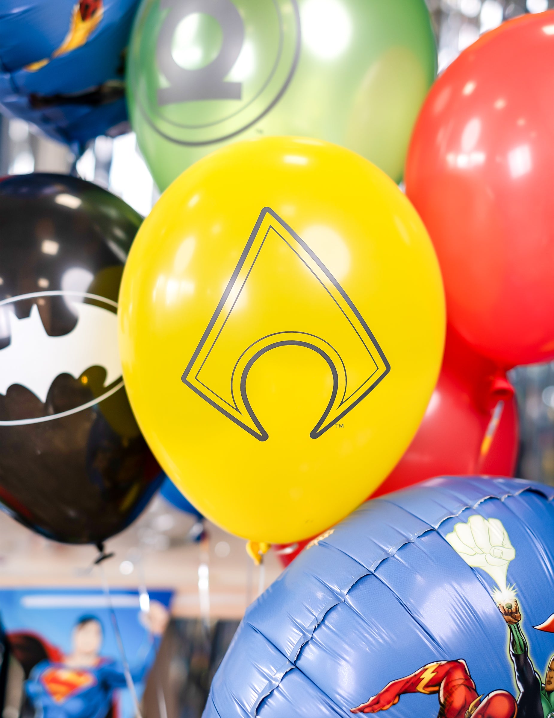 Gros plan sur le logo Aquaman des ballons latex Justice League