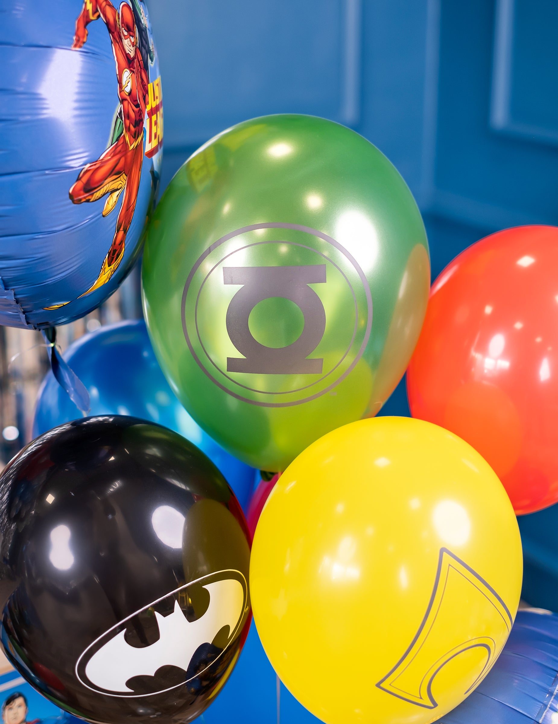 Gros plan sur les logos Green Lantern et Batman des ballons latex Justice League