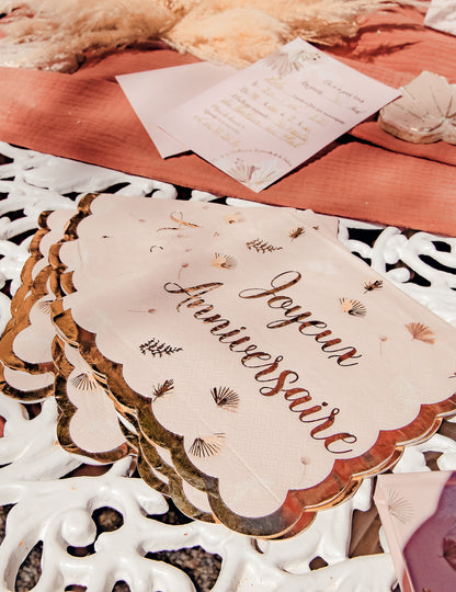 Détail de l'écriture et des bords dorés des serviettes joyeux anniversaire boho blush et or festonnées