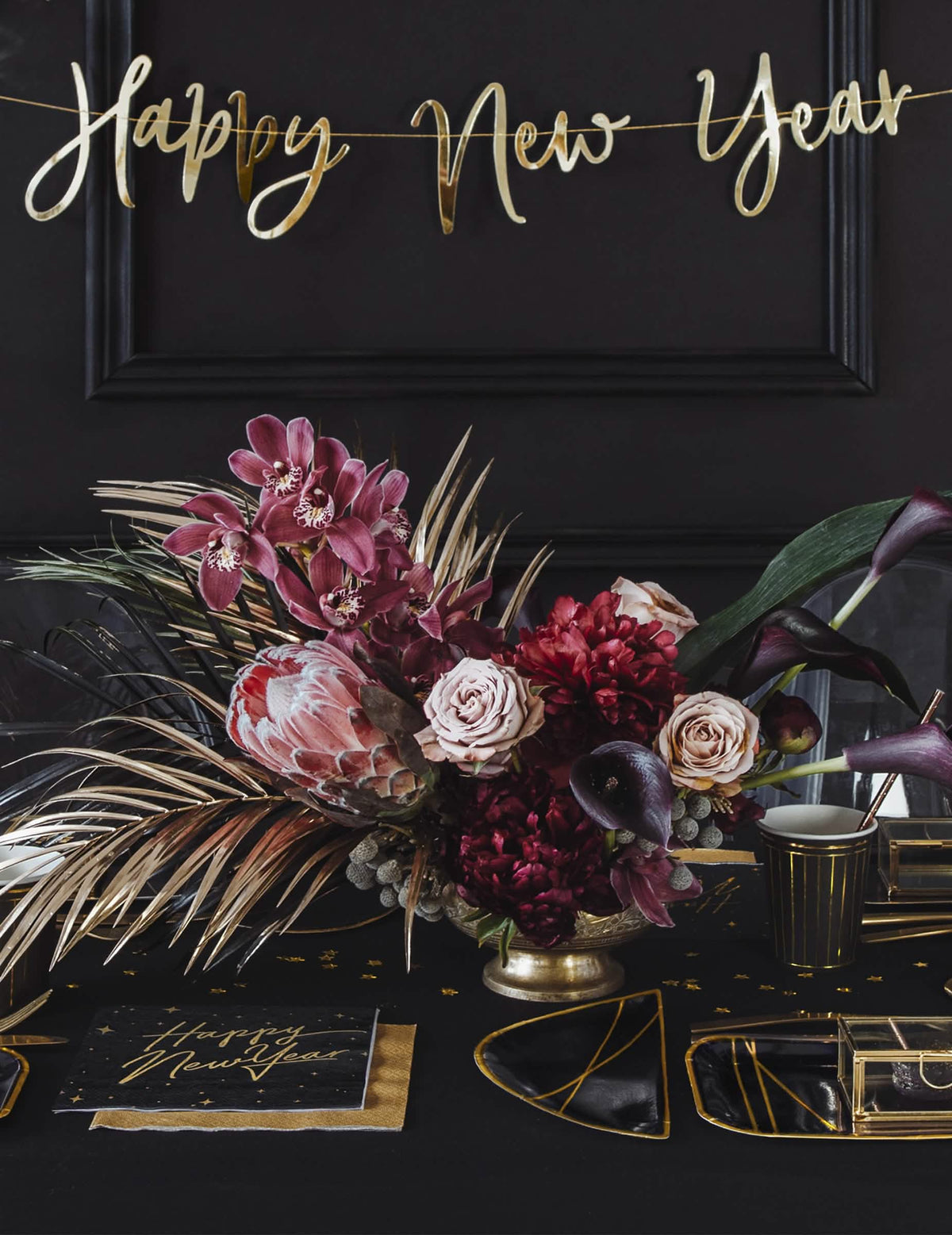 Сцена на празнична маса с черни и златни хартиени салфетки Happy New Year със звездна украса
