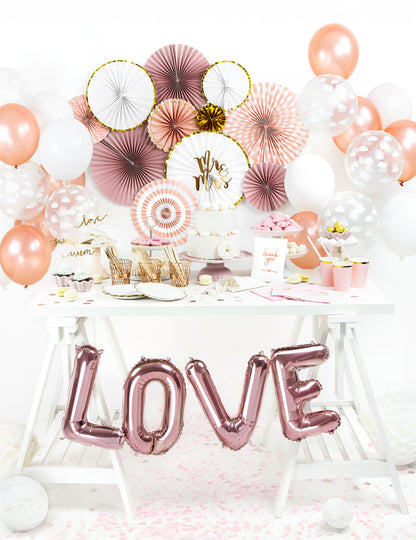 Vue d'ensemble sur une table de fête des 3 rosaces en papier blanches et dorées pour décoration