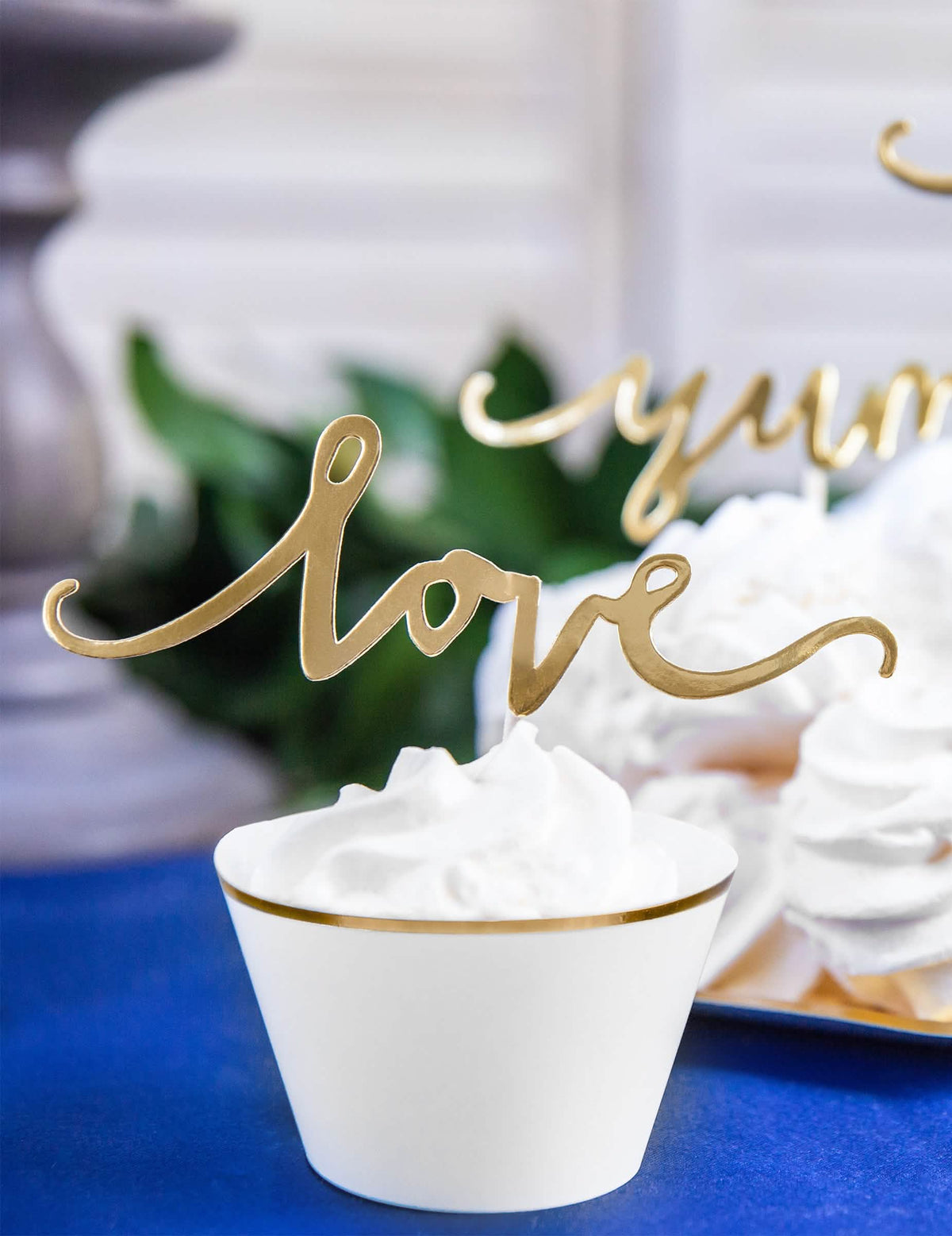 Крупен план на златен cake topper love от хартиени обвивки за кексчета за сватба