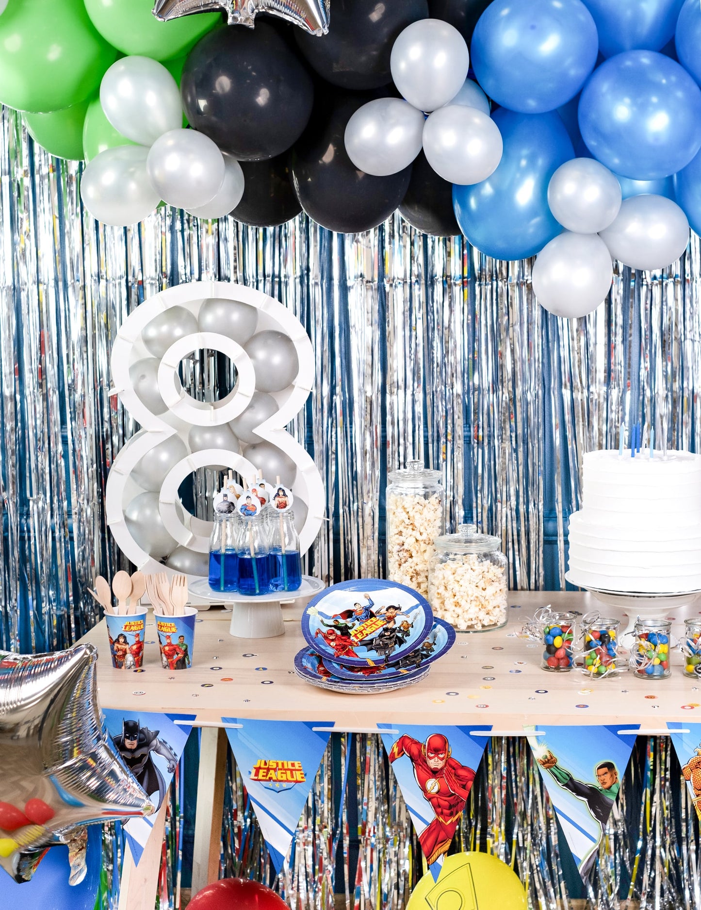 Mise en situation sur une table d'anniversaire des assiettes en carton Justice League
