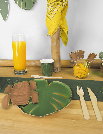 Mise en situation sur une table de fête des assiettes en carton feuilles tropicales