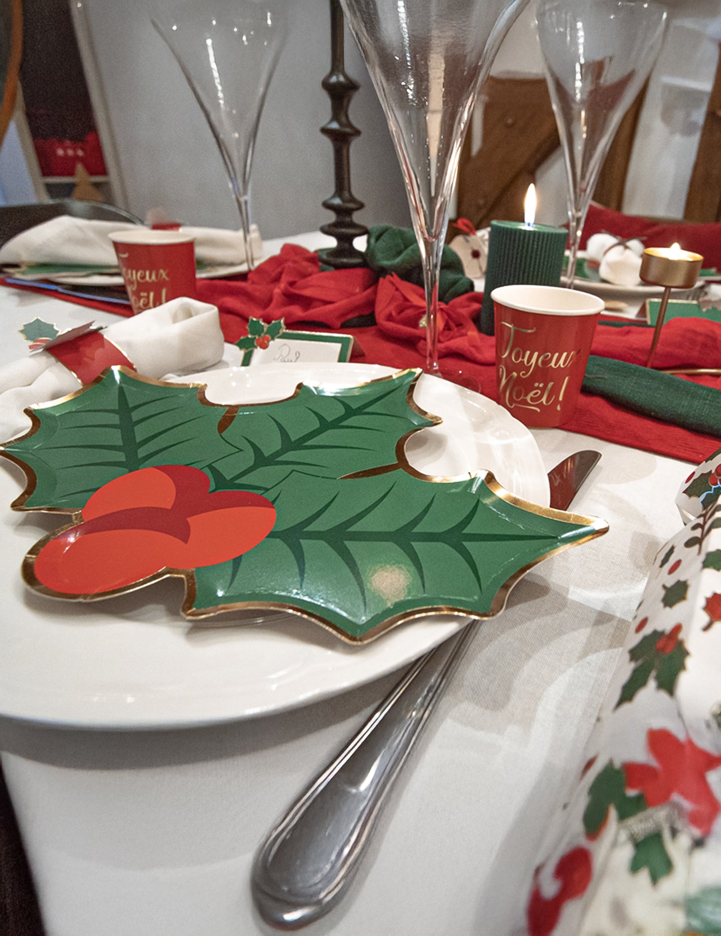 Mise en situation sur une table des assiettes en carton houx de Noël