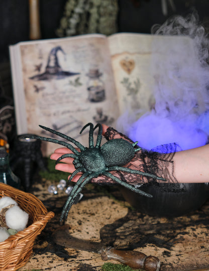 Mise en situation dans la main de l'araignée en plastique pour décoration vert irisé