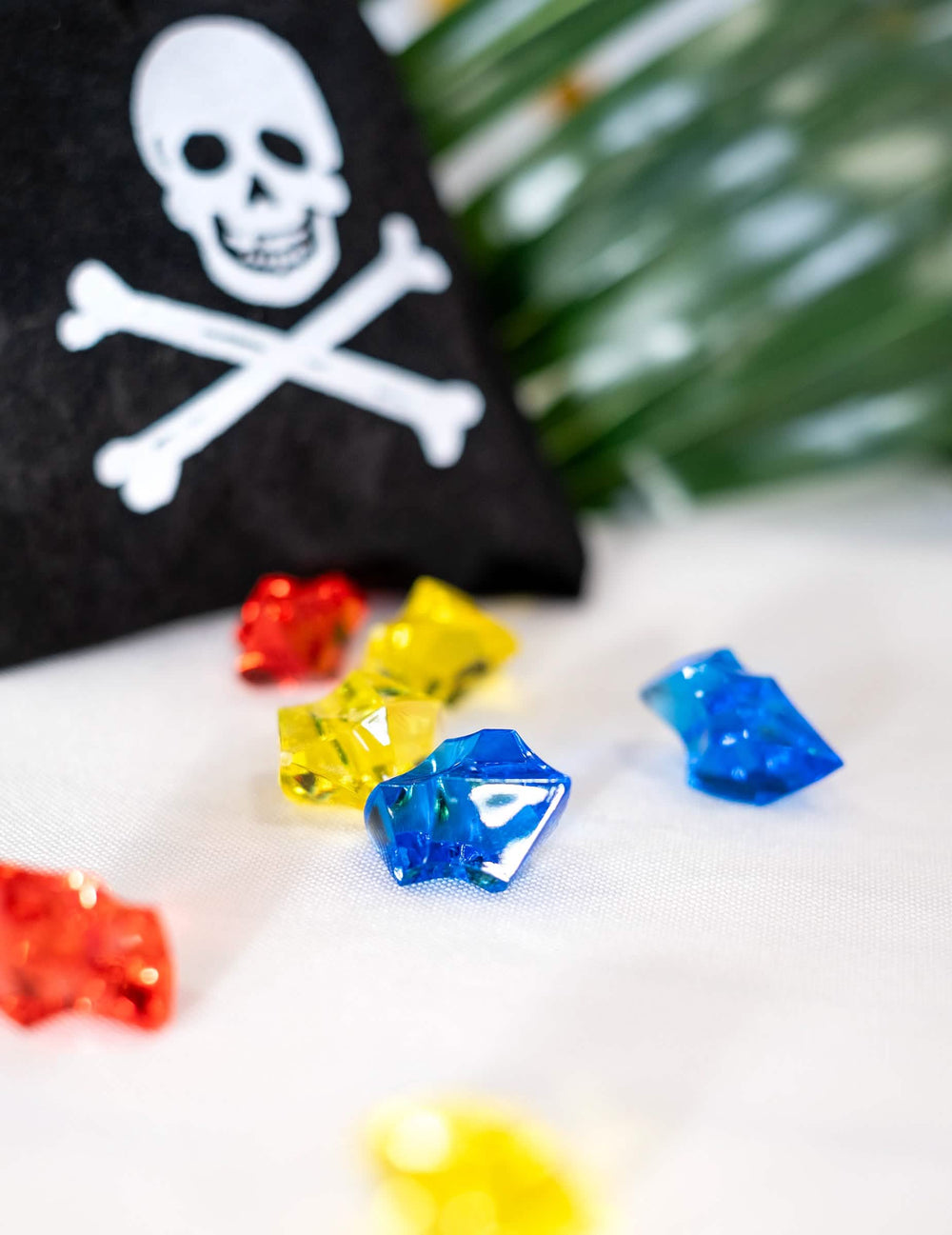 Gros plan sur les pierres précieuses multicolores de la bourse de pirate avec fausses pierres précieuses