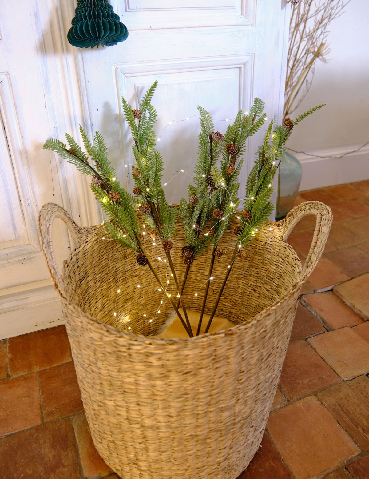 Mise en situation décorative avec guirlande lumineuse de la branche de sapin enneigée avec pommes de pin