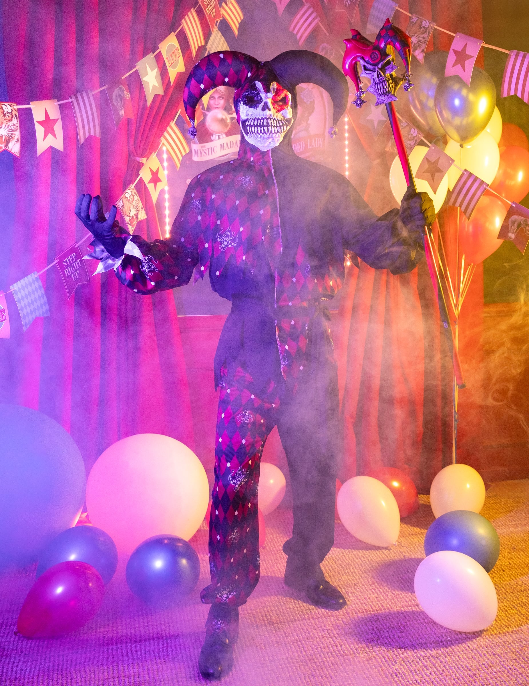 Mise en situation avec ballons et fumée du déguisement Arlequin du mal luxe pour homme