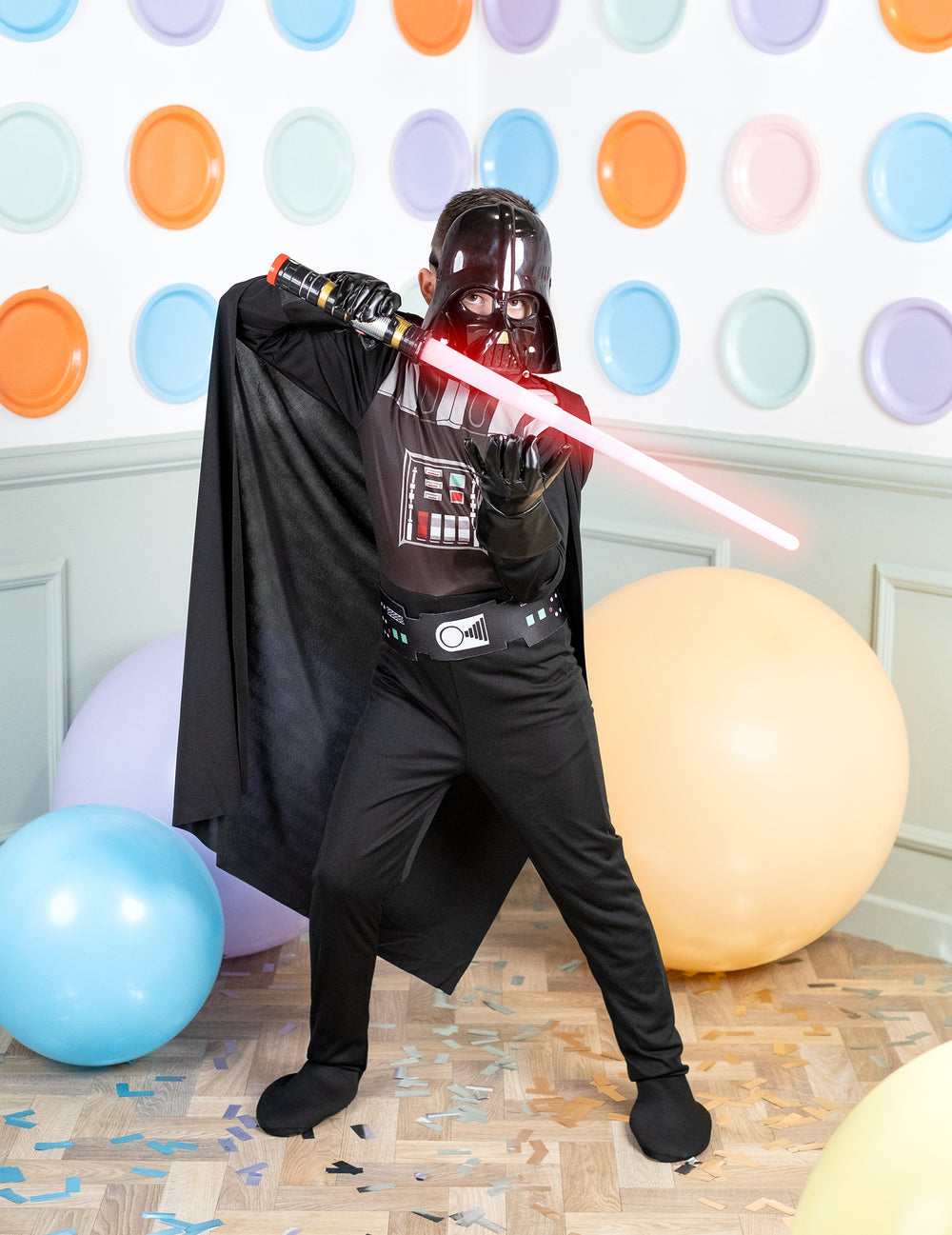 Pose d'action avec sabre laser du déguisement classique Dark Vador pour garçon