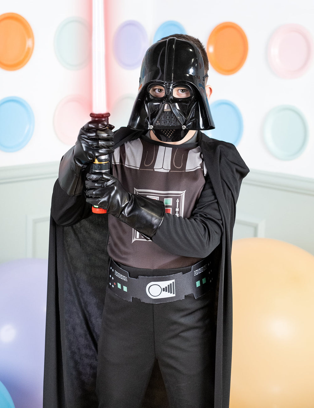 Gros plan sur le buste et le sabre laser du déguisement classique Dark Vador pour garçon
