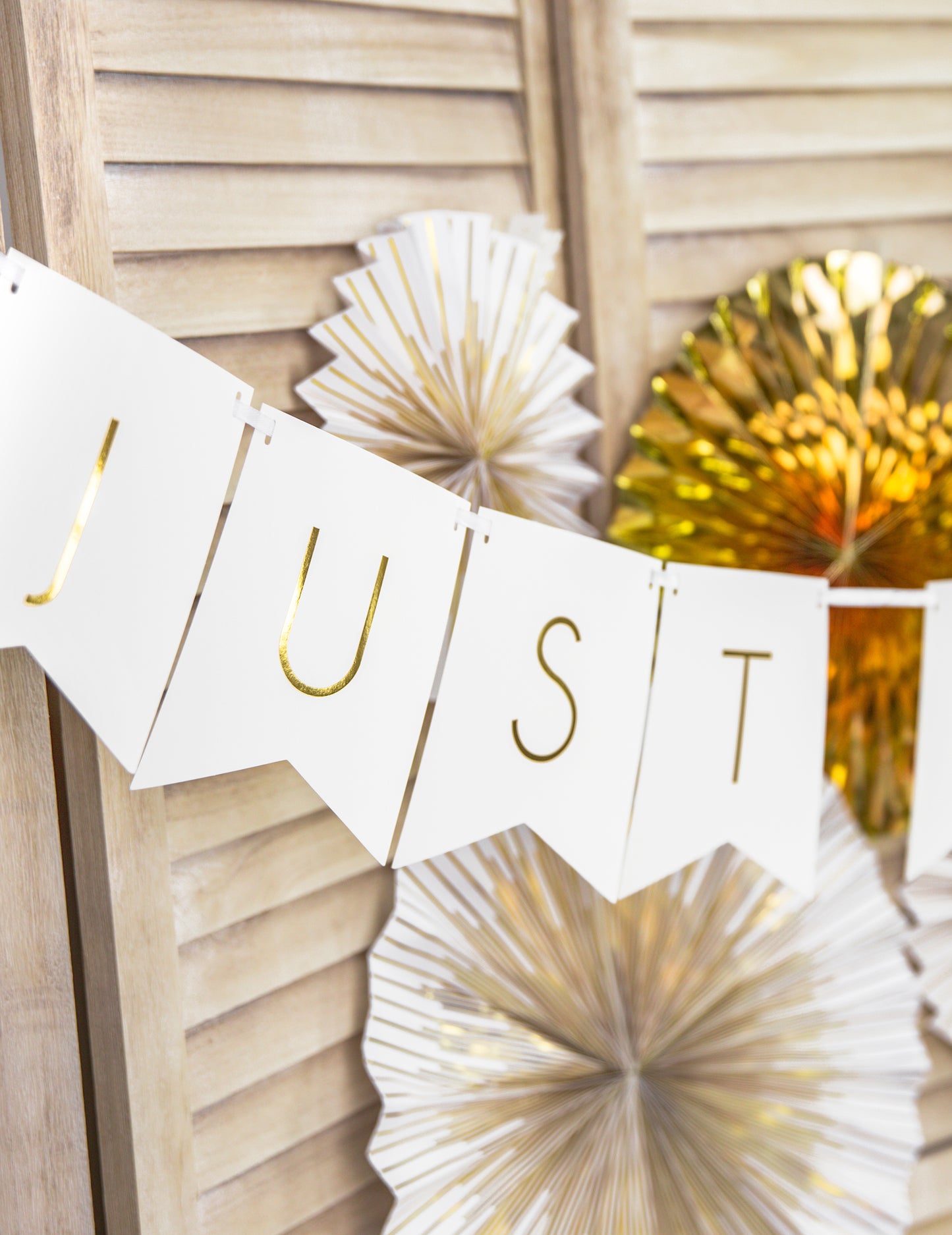 Détail de la typographie dorée de la guirlande en carton Just Married pour mariage