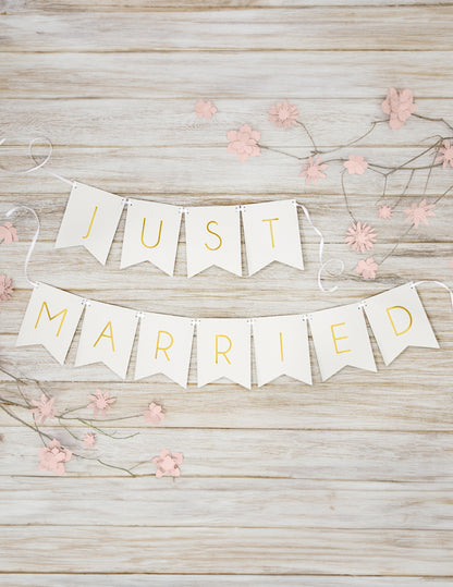 Mise en scène sur fond bois de la guirlande en carton Just Married pour mariage