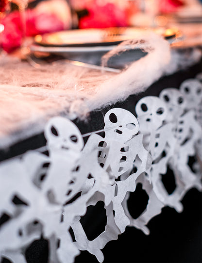 Détail de la suspension sur table de la guirlande en papier squelette pour Halloween