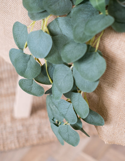 Détail de la retombée sur tissu de jute de la guirlande de feuilles d'eucalyptus
