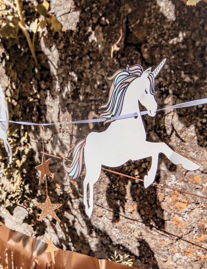 Gros plan sur le motif licorne de la guirlande licorne pastel et étoiles dorées