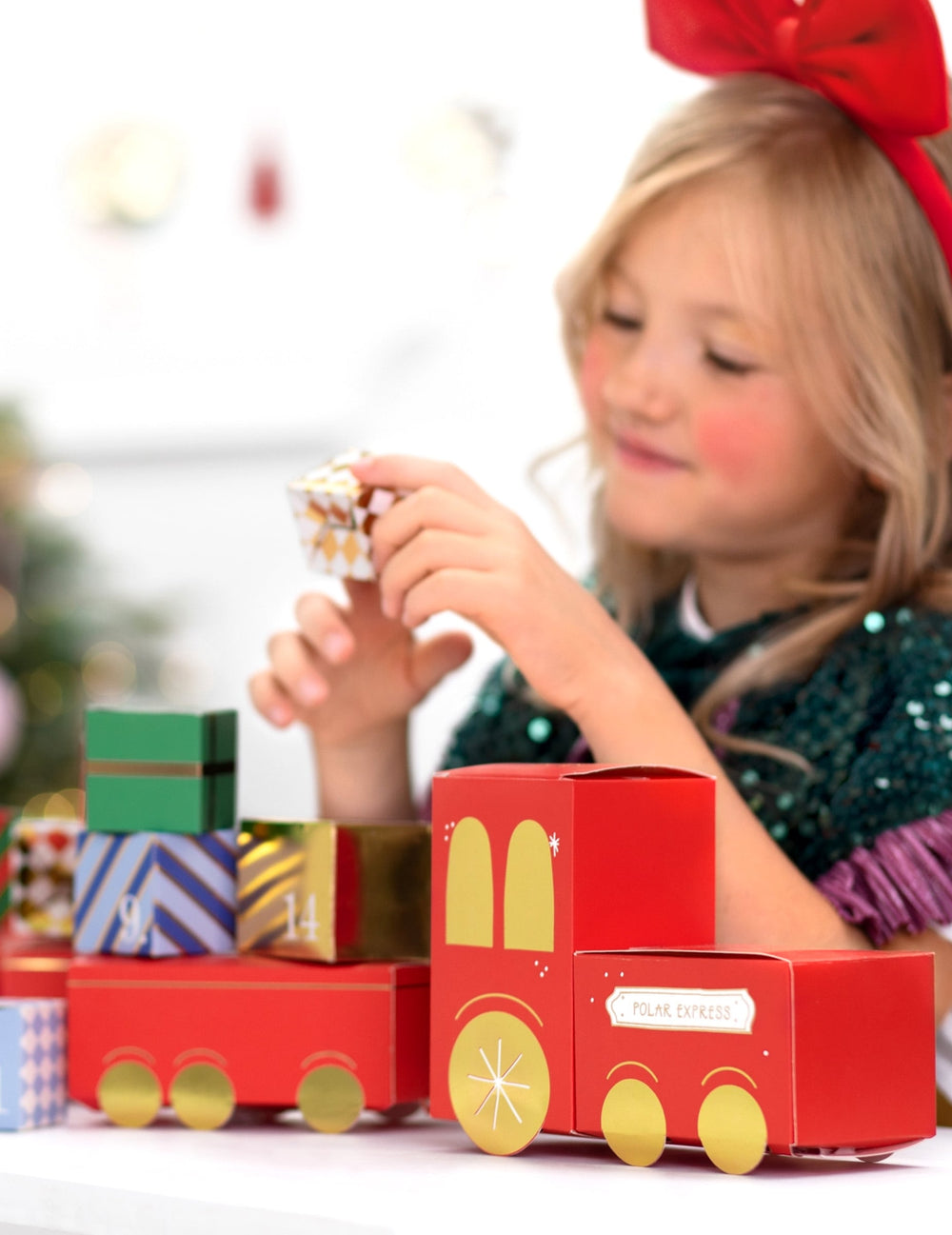Enfant manipulant une boîte du kit calendrier de l'avent diy train de Noël