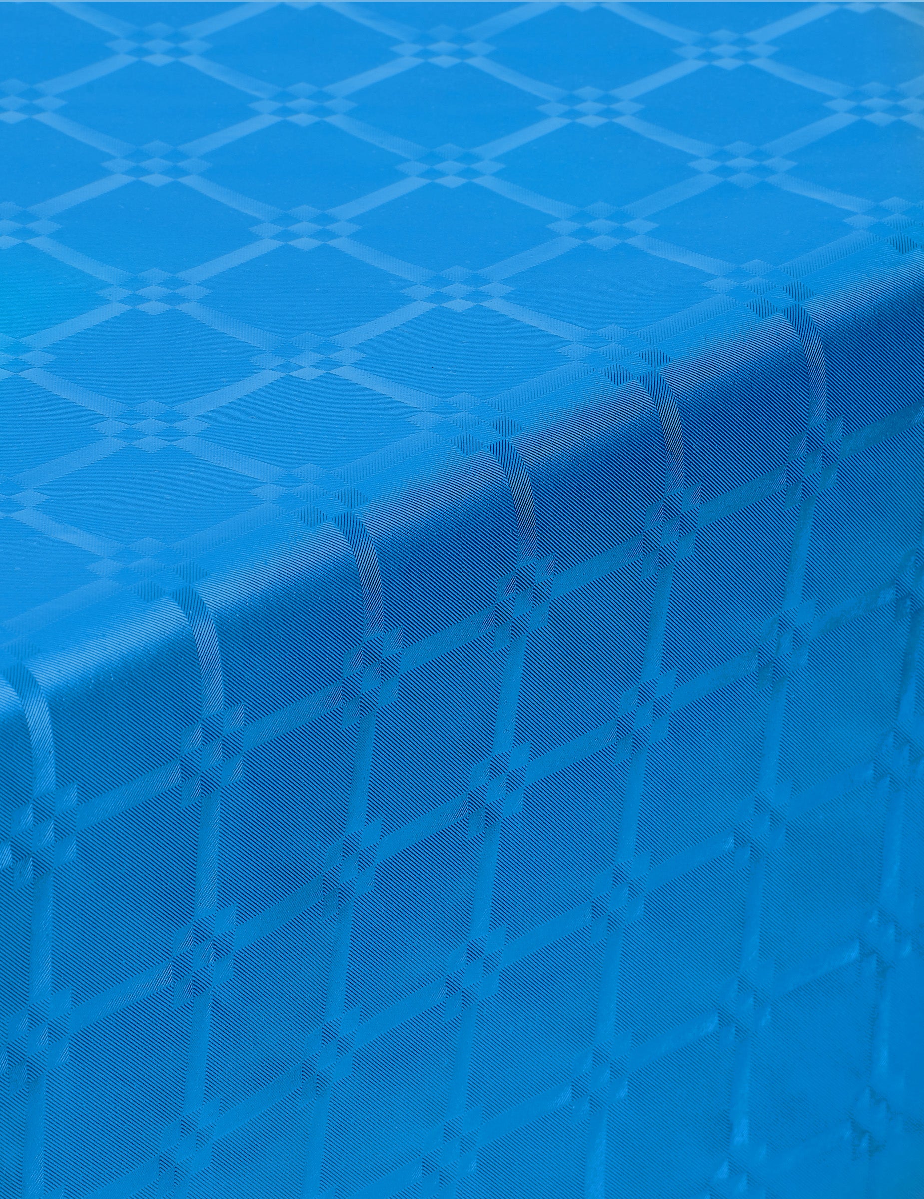 Gros plan sur le relief de la nappe en rouleau papier damassé bleu avec motifs de frises grecques