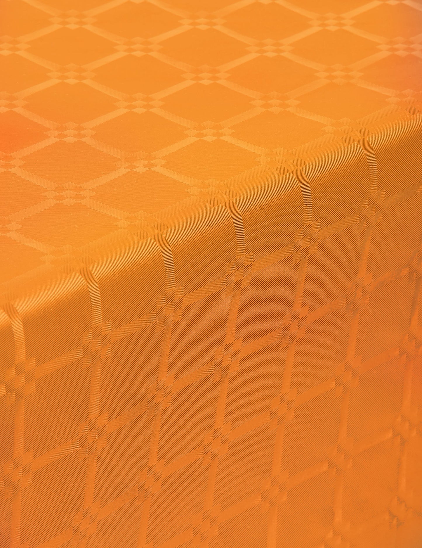 Gros plan sur les motifs de la nappe en rouleau papier damassé orange épais