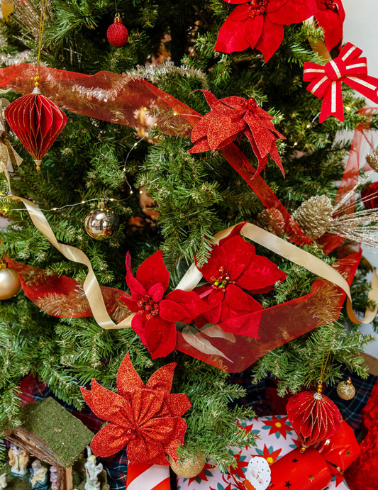 Mise en situation sur un sapin de Noël du nœud de poinsettia avec grelots pour décoration de table