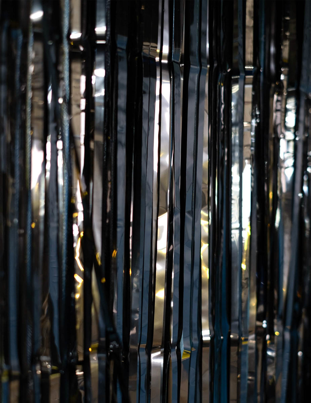 Détail des reflets sur les lamelles du rideau scintillant pour fête noir