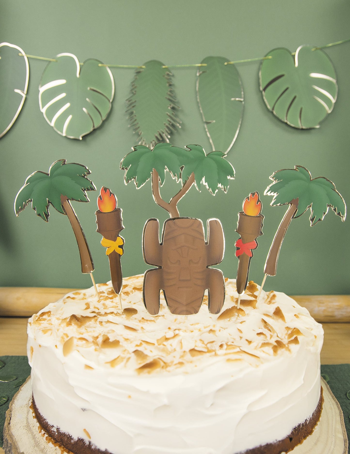 Gros plan sur les motifs tiki et palmiers des décorations pour gâteau aventurier